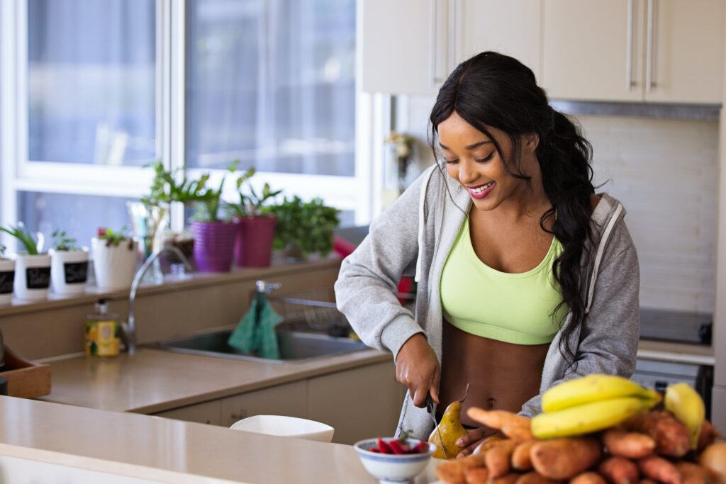 Image of a woman preparing some healthy food for herself after working out to ensure that she maintains her glow-up